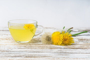 Dandelion tea in a transparent cup. Healthy herbal tea.