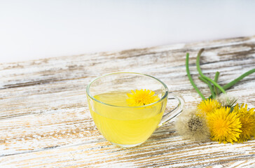 Dandelion tea in a transparent cup. Healthy herbal tea.