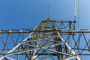 High voltage power line insulators against a clear blue sky in rural area