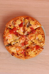 Hand holding Hawaiian pizza