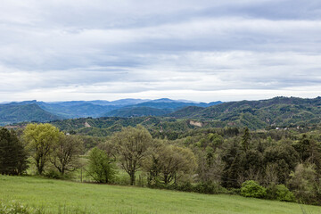 Green meadow overlooking vast valley and rolling hills on cloudy day