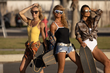 Skater girls in plaid shirts and swimsuits laughing and walking with skateboard at skate park. The summer solchechny frame.