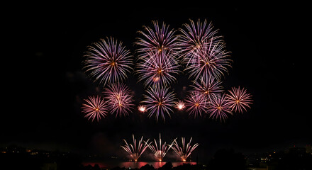 Fototapeta premium Spectacular Night Sky with Colorful Fireworks Display Over Water