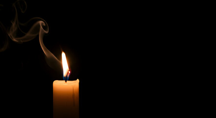 Single Candle Flame with Smoke Against Black Background