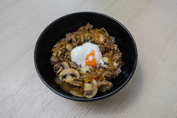 Rice bowl topped with beef, mushroom, and egg.