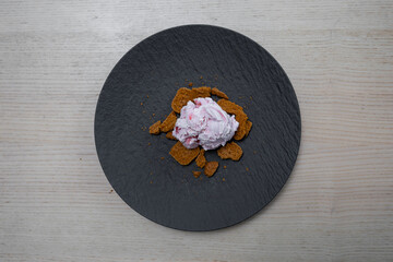 A plate of ice cream and crushed cookies.