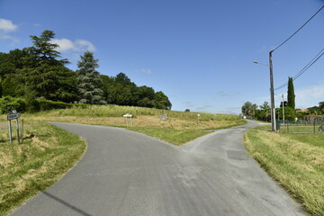 Route de campagne se divisant en deux directions près du bourg de Champagne au Périgord Vert 