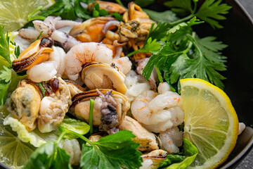 Salad seafood shrimp, mussels, squid, rapawn, prawn, green mixed leaf dish fresh food background on the table rustic food top view copy space 
