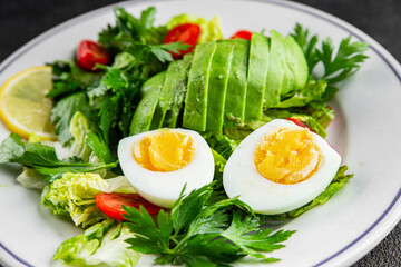 Avocado salad, boiled egg, tomato, green leaf lettuce, vegetable dish fresh delicious gourmet food background on the table rustic food top view copy space 