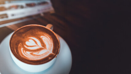 Top view of Latte arts coffe. White cup of hot coffee on wooden table. Cafe with barista art...