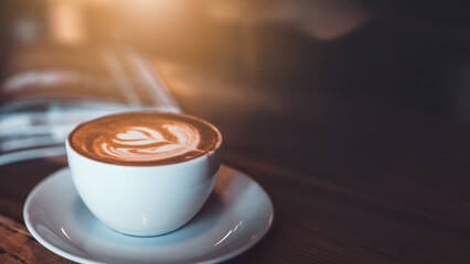 Top view of Latte arts coffe. White cup of hot coffee on wooden table. Cafe with barista art concept.	
