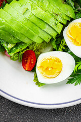 Avocado salad, boiled egg, tomato, green leaf lettuce, vegetable dish fresh delicious gourmet food background on the table rustic food top view copy space 