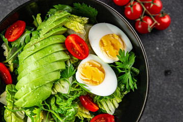 Avocado salad, boiled egg, tomato, green leaf lettuce, vegetable dish fresh delicious gourmet food background on the table rustic food top view copy space 