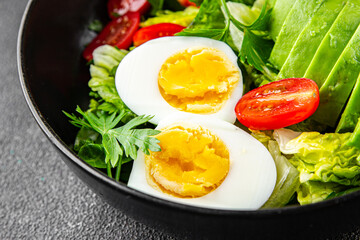 Avocado salad, boiled egg, tomato, green leaf lettuce, vegetable dish fresh delicious gourmet food background on the table rustic food top view copy space 