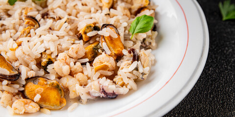 Rice seafood risotto mussel, shrimp, prawn, rapan, squid dish fresh gourmet food background on the table rustic food top view copy space
