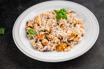 Rice seafood risotto mussel, shrimp, prawn, rapan, squid dish fresh gourmet food background on the table rustic food top view copy space