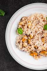 Rice seafood risotto mussel, shrimp, prawn, rapan, squid dish fresh gourmet food background on the table rustic food top view copy space