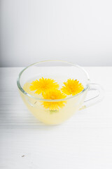 Dandelion tea in a transparent cup. Healthy herbal tea.