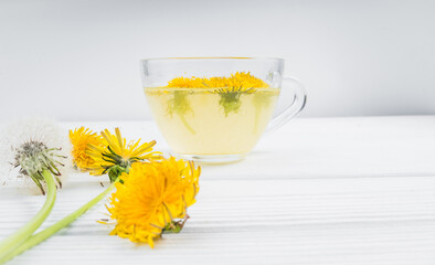 Dandelion tea in a transparent cup. Healthy herbal tea.