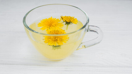 Dandelion tea in a transparent cup. Healthy herbal tea.