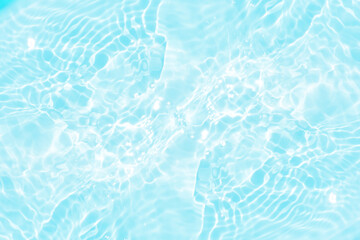 Blue water with ripples on the surface. Defocus blurred transparent blue colored clear calm water surface texture with splashes and bubbles. Water waves with shining pattern texture background.