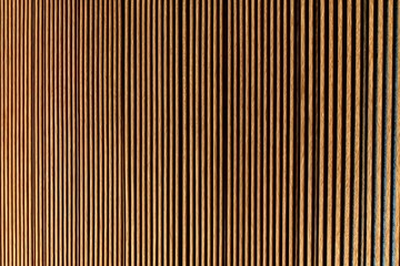 Obraz premium Vertical wooden slats form a repeating linear pattern, creating a warm and textured visual effect that highlights natural wood tones and symmetry.