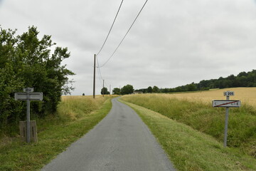 Route de campagne sous un ciel gris près du bourg de Champagne au Périgord Vert  © Photocolorsteph
