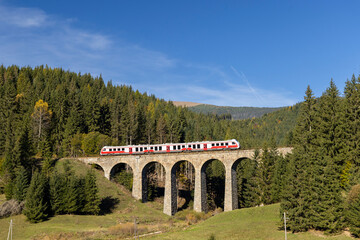 Modern diesel train, railway bridge Chramossky viadukt near Telgart, Horehronie, Slovakia