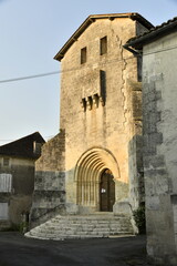 Le fronton de l'église romane sous la lumière du coucher de soleil au bourg de Champagne au Périgord Vert 