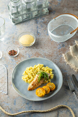 Grilled chicken breast with corn and couscous on modern blue plate
