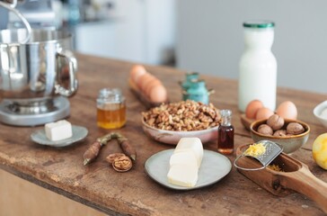 A cozy rustic kitchen features a premium stand mixer beside an array of ingredients for making Balkan Cozonac, a beloved sweet bread filled with nuts and dried fruits