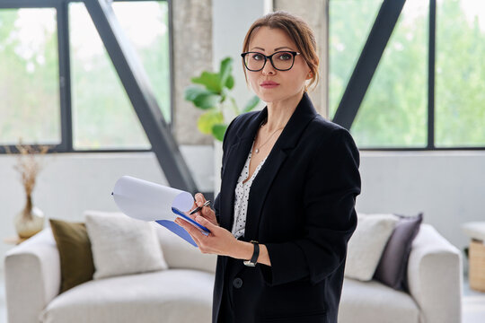 Portrait of female mental health professional with clipboard in office