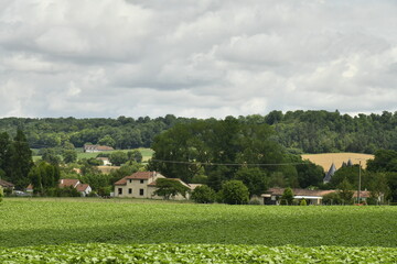 Ciel gris au dessus d'un paysage rural de collines boisées et des champs dans la vallée au bourg de Champagne au Périgord Vert  © Photocolorsteph