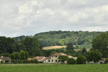 Ciel gris au dessus d'un paysage rural de collines boisées et des champs dans la vallée au bourg de Champagne au Périgord Vert 