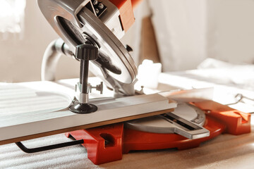 Circular saw in action as a carpenter skillfully cuts wooden planks. Hands hold the wood against the saw, showcasing precision and craftsmanship in woodworking