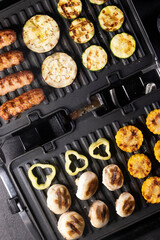 sausages and vegetables on the electric grill