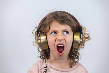 child making faces wearing vintage headphones