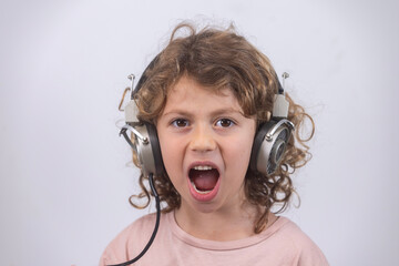 child making faces wearing vintage headphones