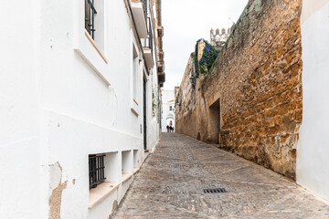 a cobbled street with typical white houses in Arcos de la Frontera, province of Cádiz, Andalusia, Spain