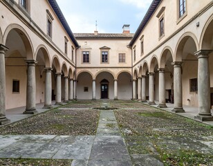 Obraz premium Serene courtyard with stone columns and arches. A peaceful architectural scene.
