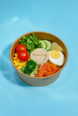 Colorful Salad Bowl with Protein and Vegetables on Blue Background