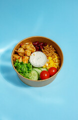 Bento Bowl with Rice and Greens on Blue Background