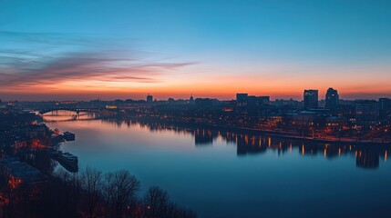 Naklejka premium City skyline at dawn over a calm river