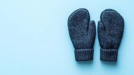Cozy knitted mittens on a light blue surface for winter season concept