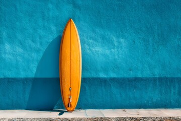 Bright Orange Surfboard Against Vibrant Blue Wall Background