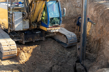 Fototapeta premium The yellow hydraulic piling machine lays Larsen dowels after extraction from the ground