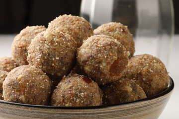 Healthy snacks, fitness lifestyle and high fiber diet concept with dates and dryfruits energy Laddus or Ladoo surrounded by dried fruits, Cashew Nuts, pistachios , almonds
