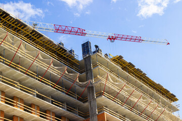 Concrete floors, brick walls and a construction crane. House construction.