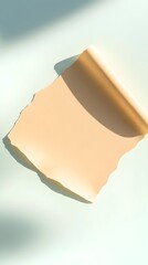 Torn peach-colored paper sheet, curled at the edge, casts a shadow on a light blue surface