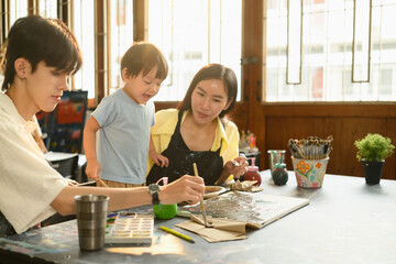 Mother, Son, and Young Art Teacher Enjoying a Painting Class, Creative Art Time with Family Concept